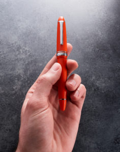 Fountain pen gripped between fingers
